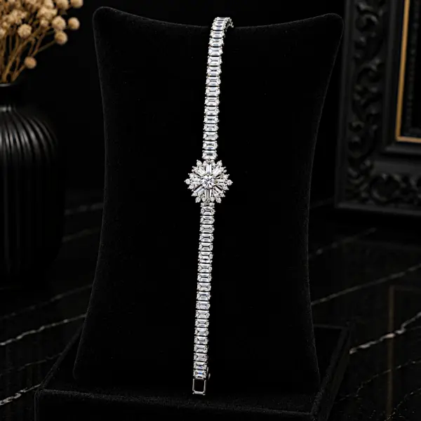 Silver zircon tennis bracelet with floral snowflake centerpiece on black display