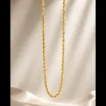 Classic gold twisted rope chain necklace suspended over elegant silk background