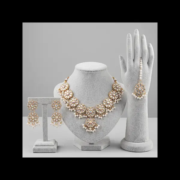 Gold floral Kundan jewelry set with necklace earrings and maang tikka featuring pearl drops
