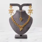 Gold filigree lace jewelry set with necklace earrings and maang tikka