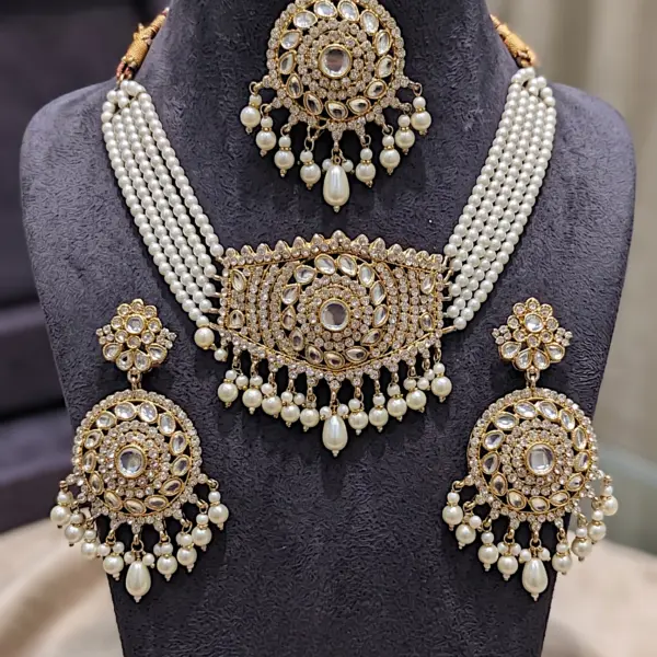Bridal Kundan jewelry set featuring a multi-strand pearl choker necklace, matching circular drop earrings, and maang tikka